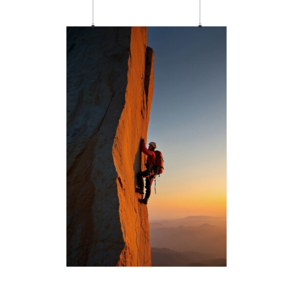 climber scaling a steep rock face at sunset with distant mountains