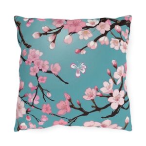 Outdoor pillow with pink cherry blossoms and a butterfly on a turquoise background.