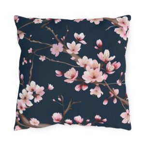 Outdoor pillow with pink cherry blossoms on a dark navy background.