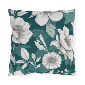 Outdoor pillow with white and gray floral design on a dark teal background