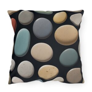 outdoor pillow featuring a pattern of smooth, multicolored stones in shades of beige, gray, blue, and white on a black background