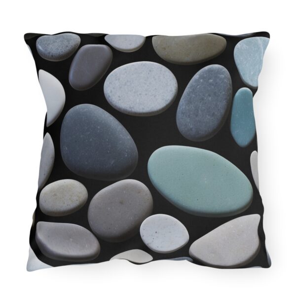 outdoor pillow featuring a pattern of smooth, multicolored stones in shades of blue, gray, and white on a black background