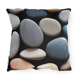 outdoor pillow featuring a pattern of smooth, multicolored stones with various textures on a black background