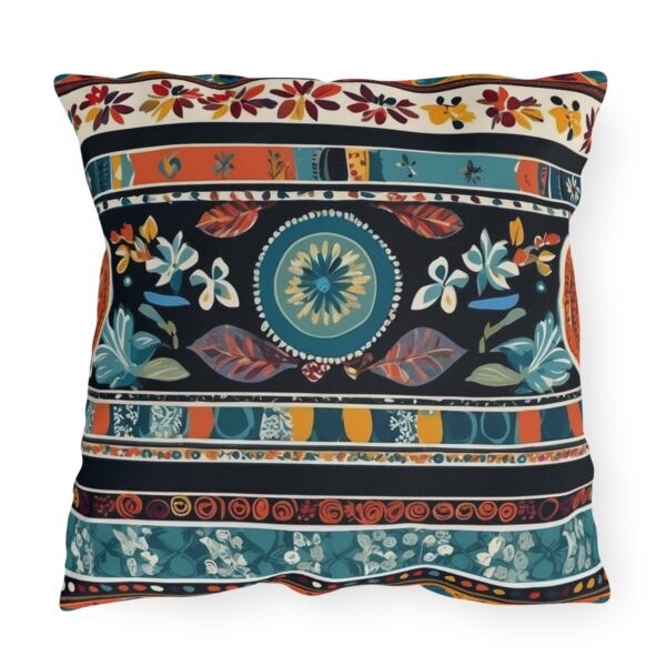 Outdoor pillow with intricate cultural patterns and textiles in vibrant colors on a dark background.