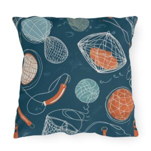 Outdoor pillow featuring a dark blue background with fishing nets, buoys, and ropes in orange and green accents