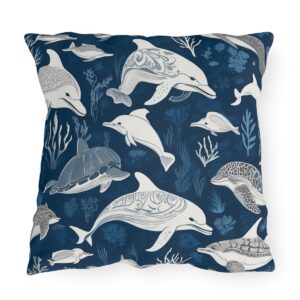 outdoor pillow featuring dolphins, turtles, and sea creatures in gray and white on a dark blue background