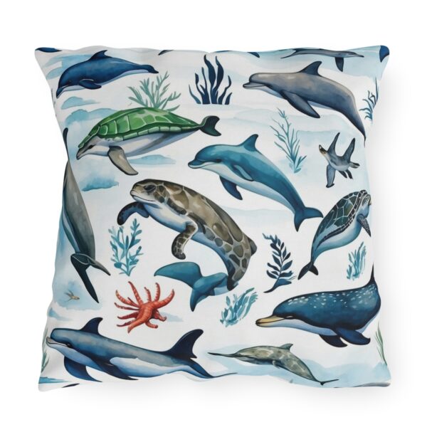 outdoor pillow featuring dolphins, turtles, and sea creatures on a light ocean background