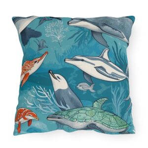 outdoor pillow featuring dolphins, turtles, and other sea creatures swimming on a blue ocean background