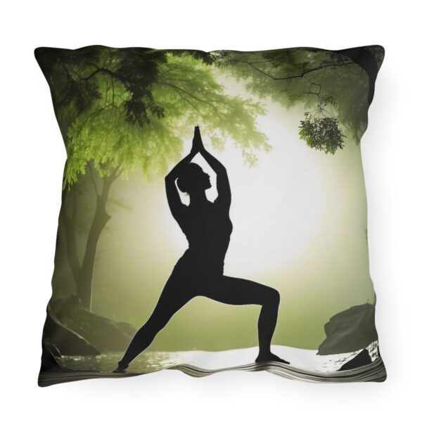 outdoor pillow with black silhouette of woman in yoga pose in front of green forest background