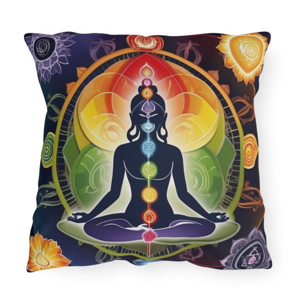 Outdoor pillow with a design featuring a meditating figure with colorful chakra symbols on a dark multicolored background.