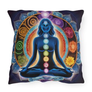 Outdoor pillow with a design featuring a meditating figure with colorful chakra symbols on a dark background.