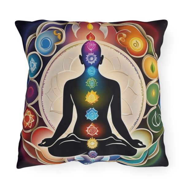 Outdoor pillow with a design featuring a meditating figure with chakra symbols on a colorful background.