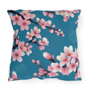 Outdoor pillow with pink cherry blossoms on a blue background.