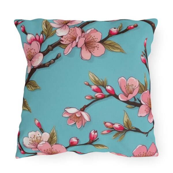 Outdoor pillow with pink cherry blossoms on a light blue background.