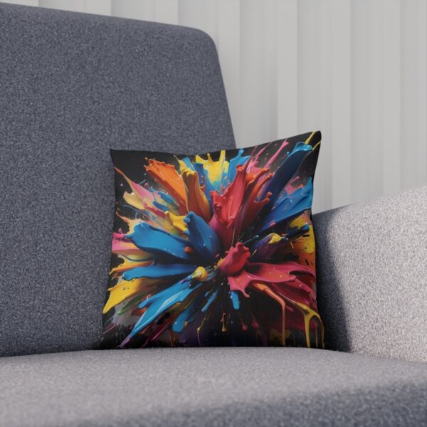 Cushion with dynamic multicolored paint splashes on gray chair