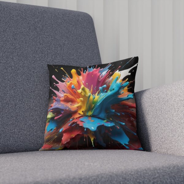 Abstract cushion with vibrant paint burst design on gray chair