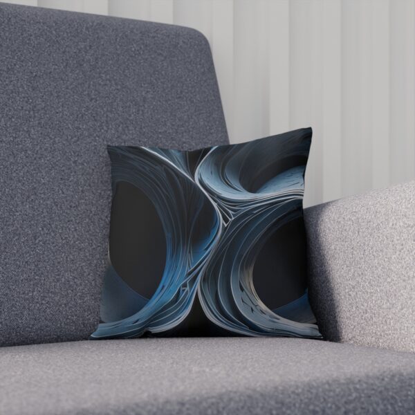 Abstract cushion with blue swirls creating a dimensional effect on gray chair