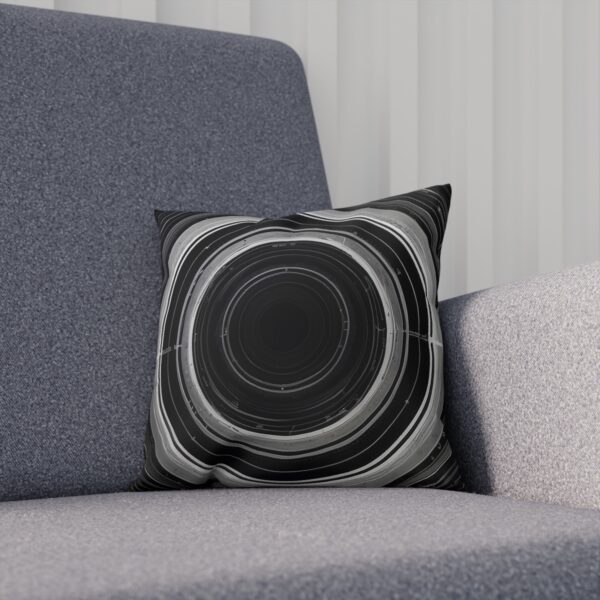 Cushion with grayscale orbital rings on a gray fabric chair