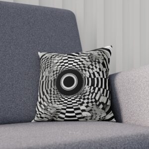 Black and white optical illusion cushion on a grey sofa.