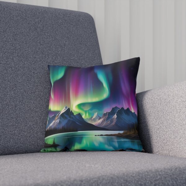 Cushion with abstract Northern Lights and mountain reflection on a grey sofa