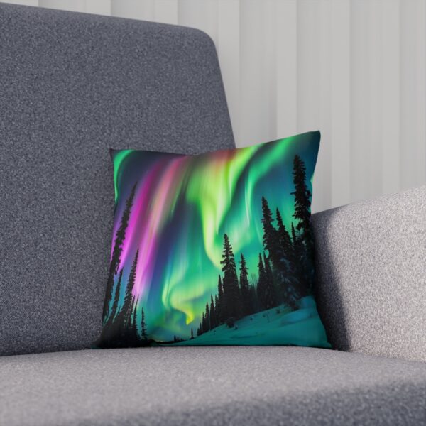 Cushion with abstract Northern Lights over pine trees on grey sofa