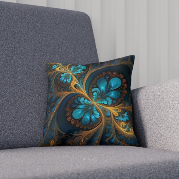 Cushion with a blue floral fractal pattern on a dark background on a couch.