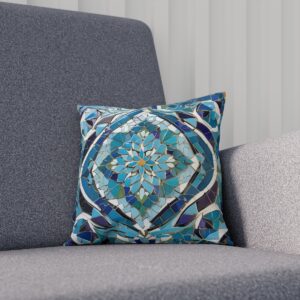 Cushion with teal and navy blue mosaic pattern on a gray couch.