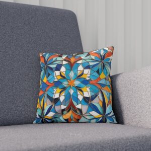 Decorative cushion with blue and orange mosaic floral pattern on a gray couch.