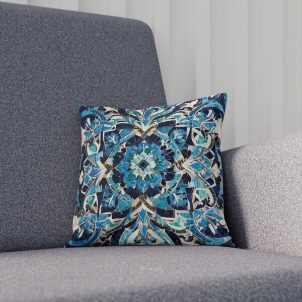 Dark blue and gold mosaic tile pattern cushion on a gray couch.