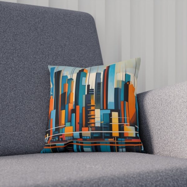 Artistic cushion with a stylized city skyline design on a grey couch.