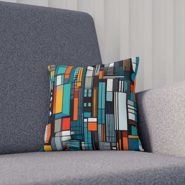 Cushion with colorful geometric urban pattern on a grey sofa.