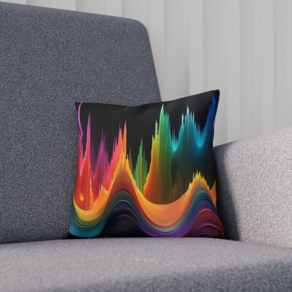 Cushion with vibrant abstract sound wave design on a grey couch.