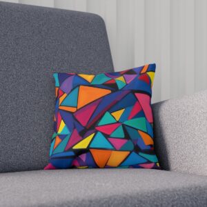 Cushion with colorful geometric triangles on a gray couch.