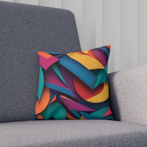 Abstract geometric design cushion on a gray sofa.