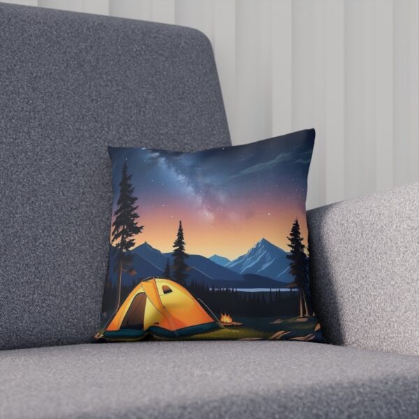 Cushion with twilight camping scene and starry transition on a grey couch.