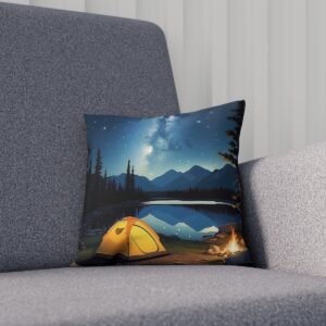 Cushion featuring a campsite by a lake under a starry sky on a sofa.