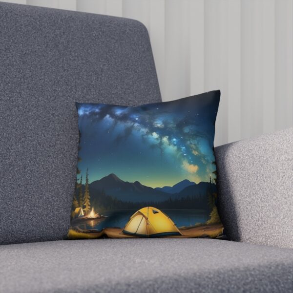 Cushion with a camping under starry sky design on a sofa.