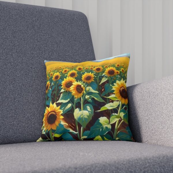 Cushion with detailed sunflower print against a grey sofa backdrop.