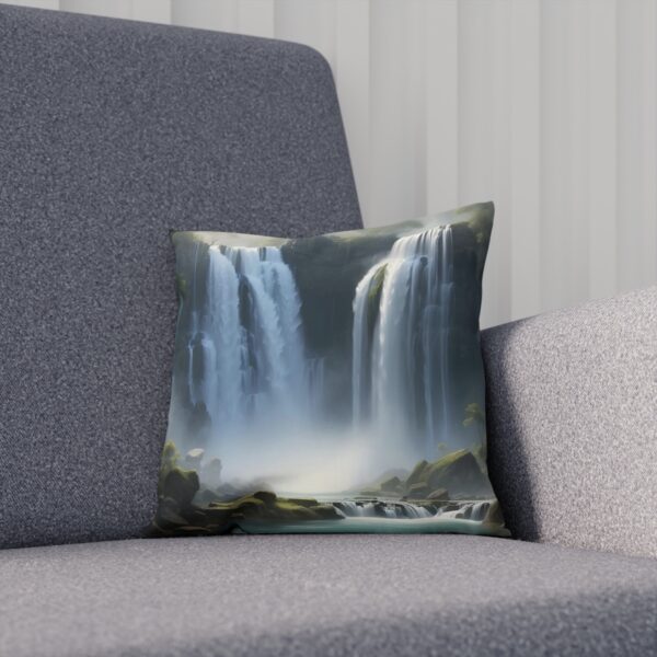 Square cushion with a misty waterfall scene on a grey couch.