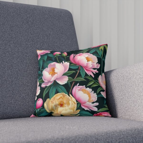 Cushion adorned with blooming peonies on a rich green backdrop on sofa