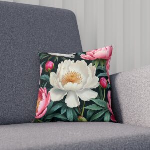 Cushion with a white peony and pink buds on dark green foliage on sofa