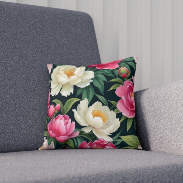 Cushion with white and pink peony flowers on a dark background on sofa