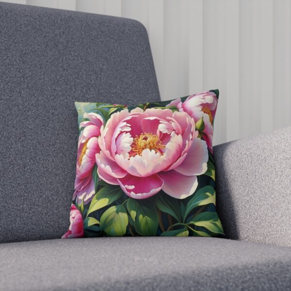 Decorative cushion featuring a detailed pink peony on foliage background on sofa