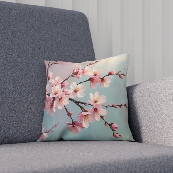 Pink cherry blossoms on a cushion with soft blue backdrop on sofa