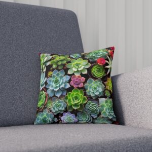 Succulent cushion with green and pink tones on dark background on sofa