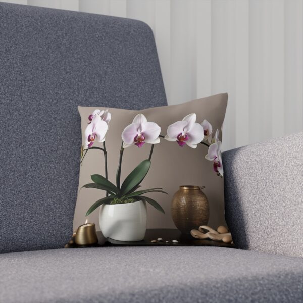 Cushion with orchid plant and decorative vases on a beige surface