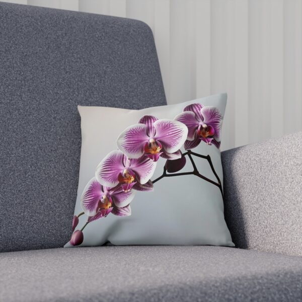 Cushion with vibrant pink orchids against a soft backdrop