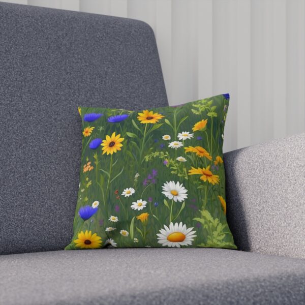 Floral cushion with vibrant daisies and cornflowers on green