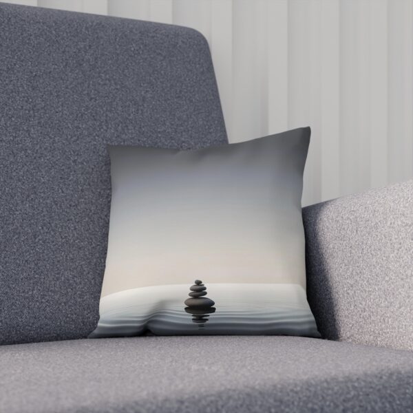 Zen-inspired cushion with stacked stones design on gray chair