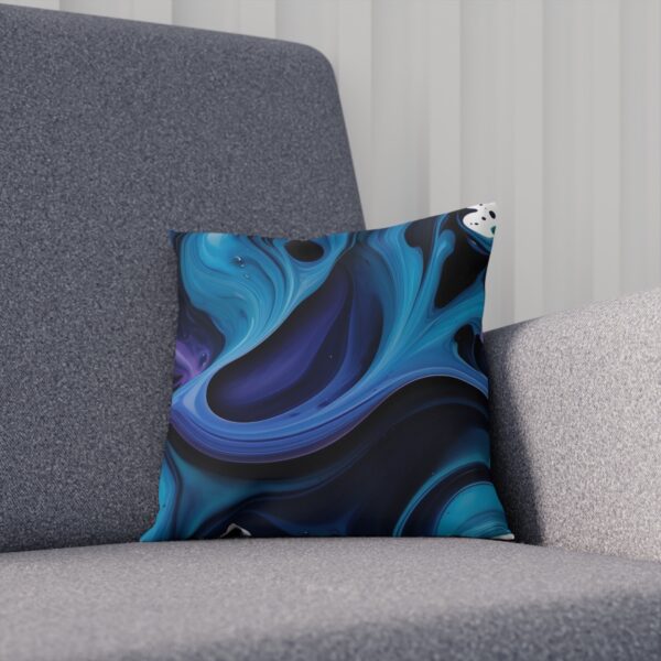 Cushion with flowing blue ink design on a gray textured chair